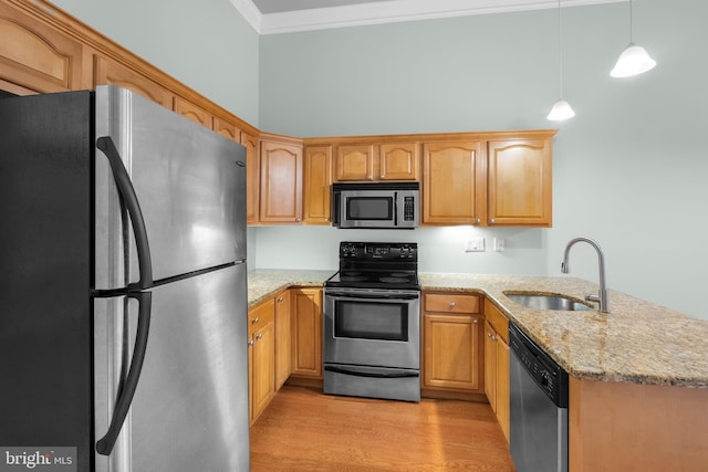 kitchen featuring sink, ornamental molding, appliances with stainless steel finishes, decorative light fixtures, and light stone counters