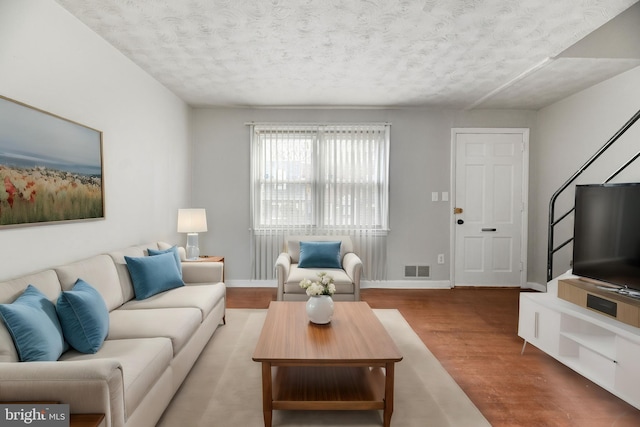 living room featuring light hardwood / wood-style floors and a textured ceiling