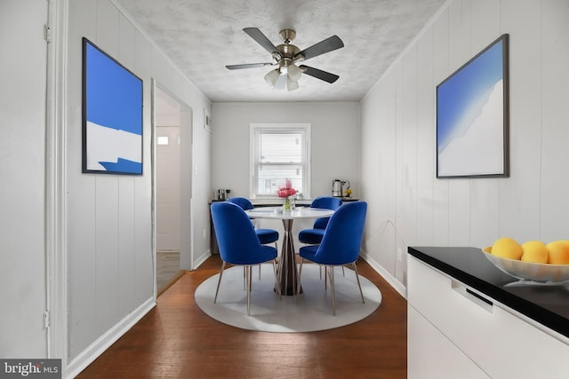 dining area with wood-type flooring, ceiling fan, and a textured ceiling