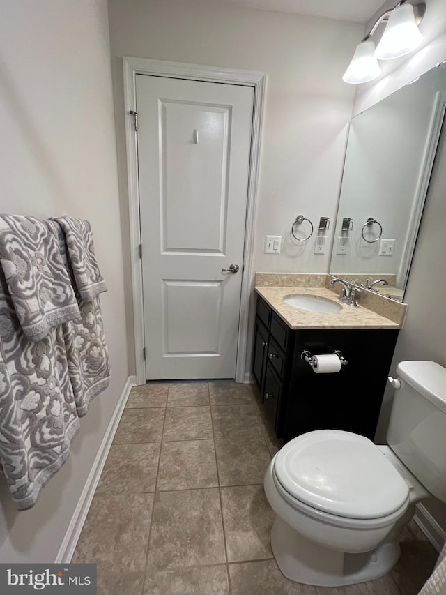 bathroom featuring vanity, tile patterned flooring, and toilet