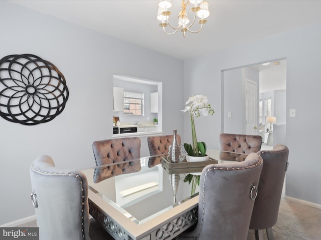 carpeted dining area featuring sink and an inviting chandelier