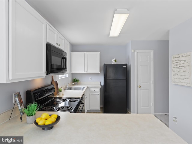 kitchen featuring sink, black appliances, and white cabinets