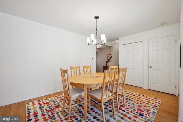 dining space with an inviting chandelier and light hardwood / wood-style flooring