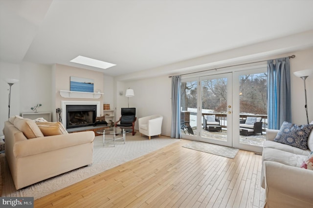 living room featuring a skylight and hardwood / wood-style flooring