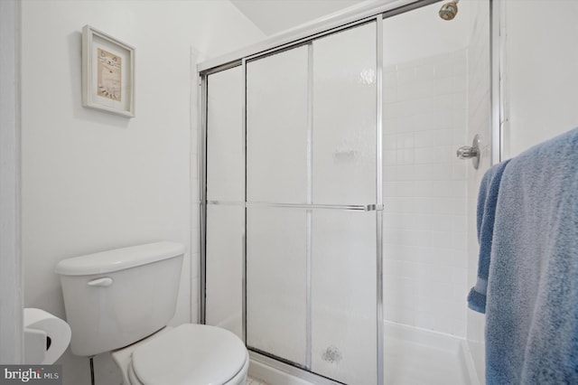 bathroom with a shower with shower door and toilet