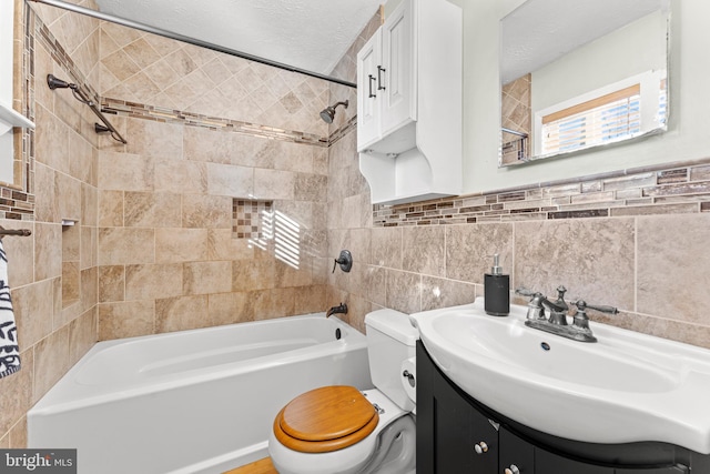 full bathroom with tile walls, vanity, a textured ceiling, toilet, and tiled shower / bath