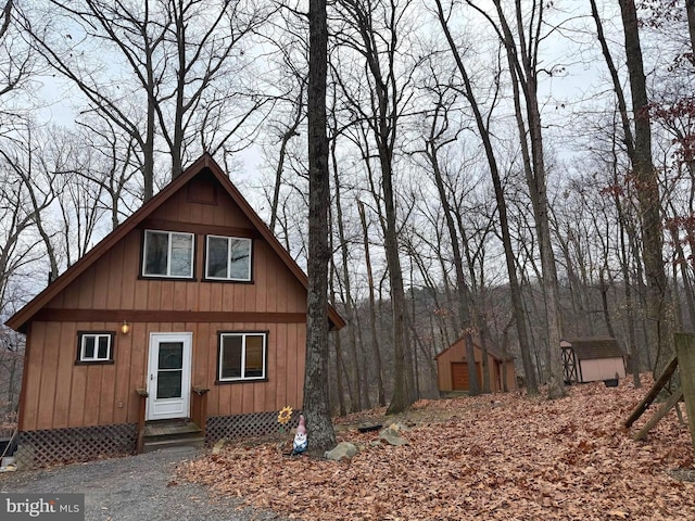 view of side of home featuring a storage shed