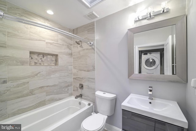 full bathroom with vanity, toilet, tiled shower / bath, and stacked washer and clothes dryer