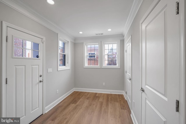 entrance foyer with light hardwood / wood-style flooring, plenty of natural light, and crown molding