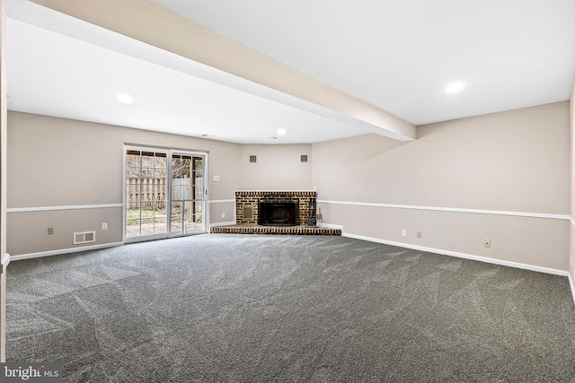 unfurnished living room with beamed ceiling, carpet flooring, and a brick fireplace