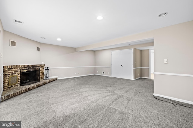 unfurnished living room featuring carpet and a brick fireplace