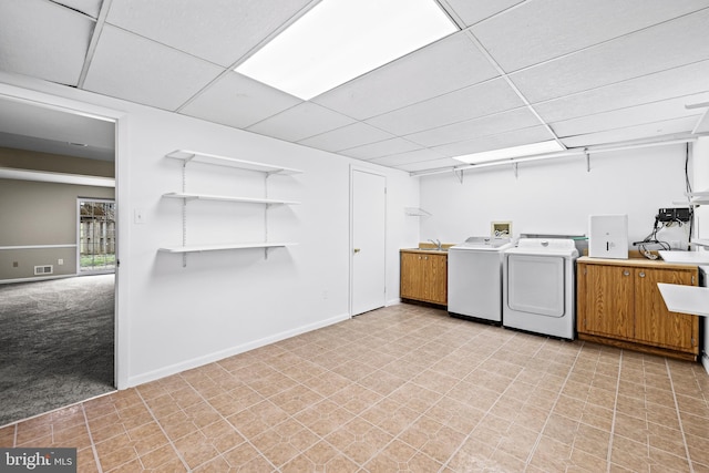 laundry area with separate washer and dryer, light colored carpet, and cabinets