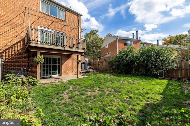 back of property with a yard, a balcony, and cooling unit