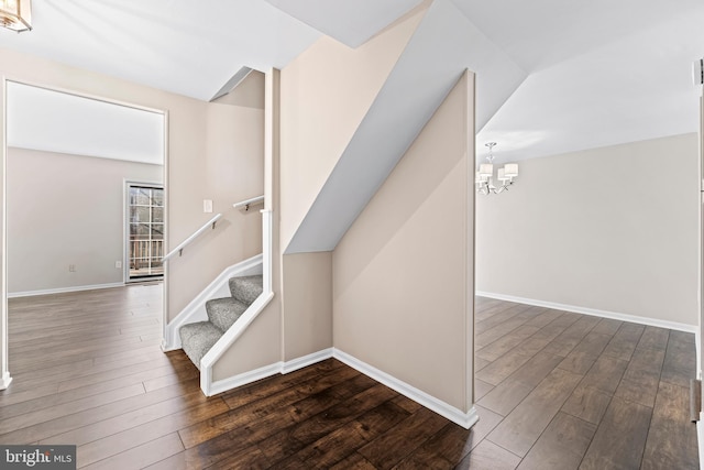 staircase featuring a chandelier and wood-type flooring