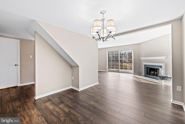 unfurnished living room with lofted ceiling, dark hardwood / wood-style floors, and a notable chandelier