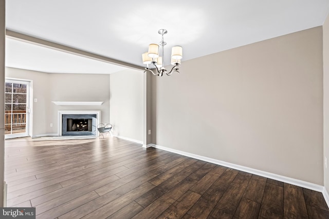 unfurnished living room featuring hardwood / wood-style floors and an inviting chandelier