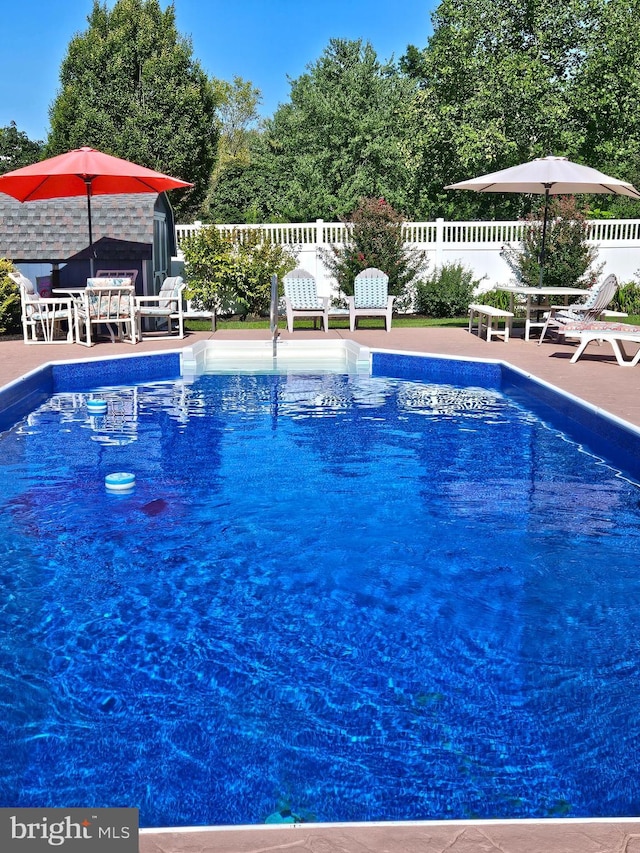 view of pool with a fenced in pool, a patio, and fence