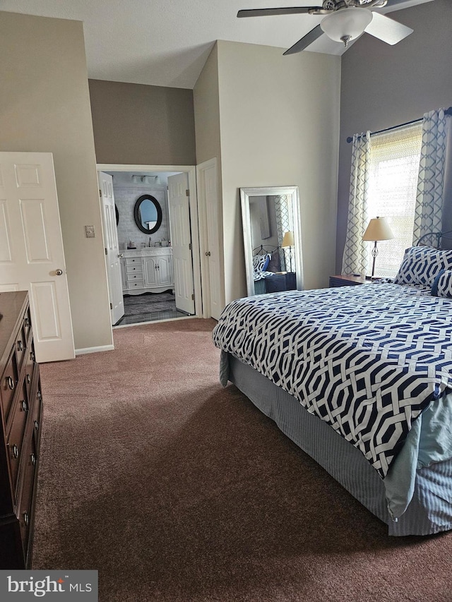 bedroom featuring ensuite bath, a ceiling fan, baseboards, and carpet floors