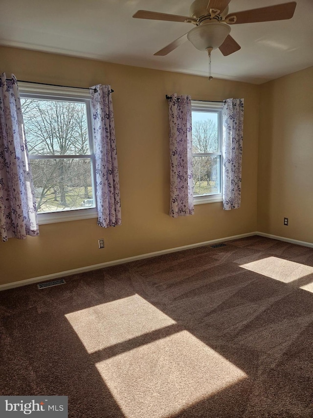 empty room featuring visible vents, ceiling fan, baseboards, and carpet