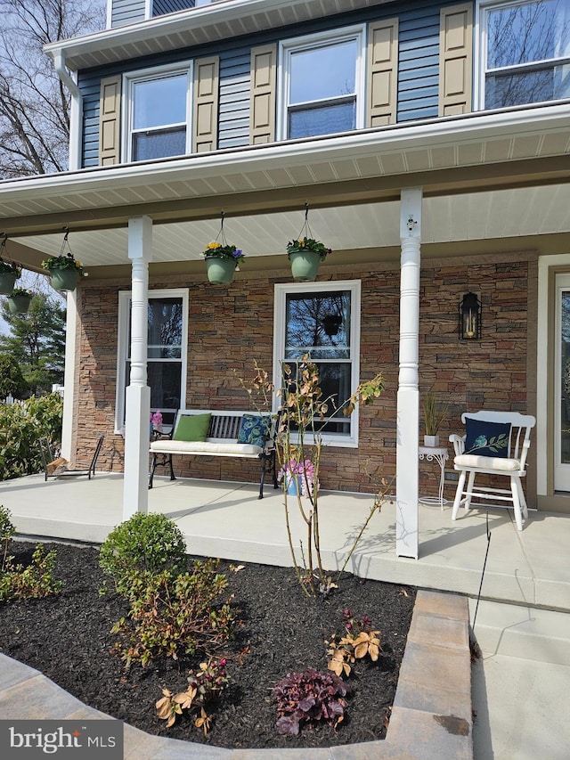 entrance to property featuring stone siding and covered porch