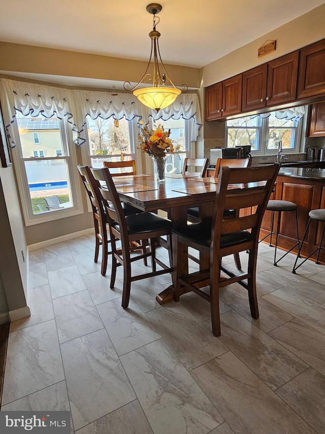 dining room with marble finish floor and baseboards