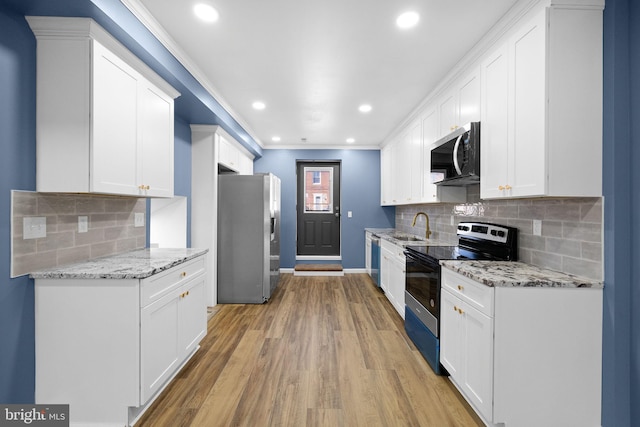 kitchen featuring white cabinets, decorative backsplash, and stainless steel appliances