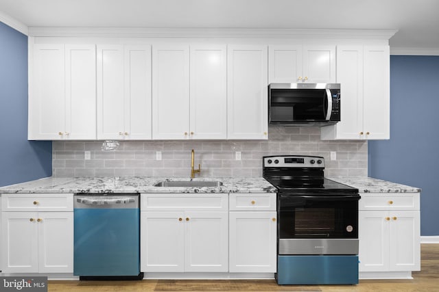 kitchen with white cabinetry, sink, stainless steel appliances, and light stone counters