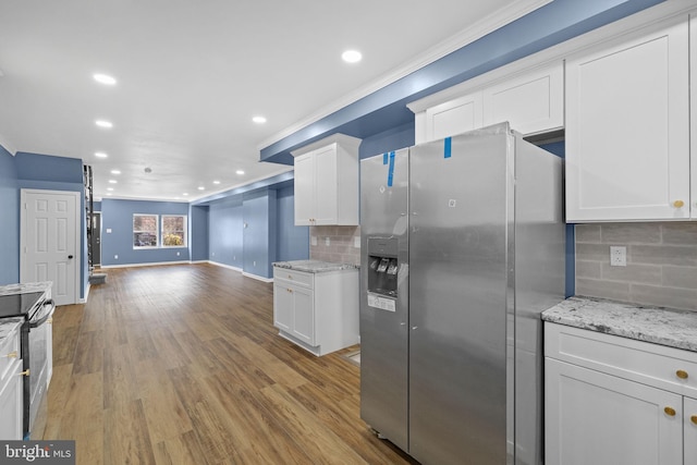 kitchen with backsplash, light stone counters, stainless steel appliances, hardwood / wood-style flooring, and white cabinetry