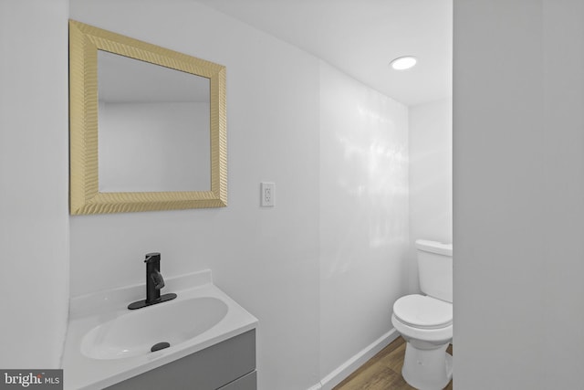 bathroom featuring vanity, wood-type flooring, and toilet