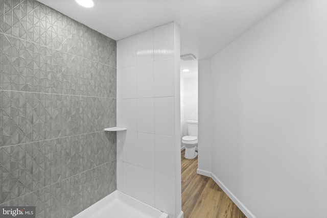 bathroom featuring hardwood / wood-style flooring, toilet, and walk in shower