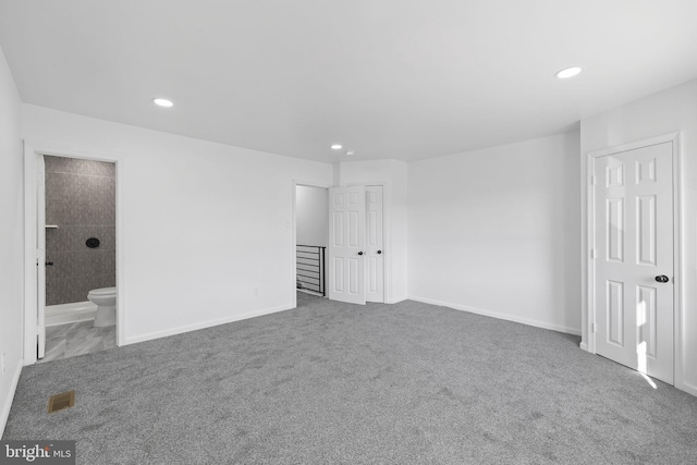 unfurnished bedroom featuring carpet flooring and connected bathroom