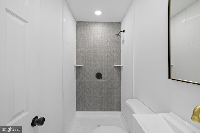 bathroom with toilet and tiled shower