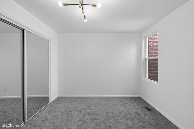 unfurnished bedroom featuring dark colored carpet and a closet