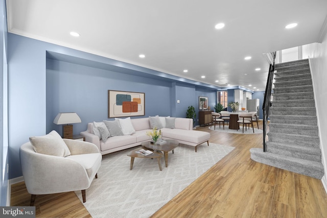 living room with crown molding and light hardwood / wood-style flooring