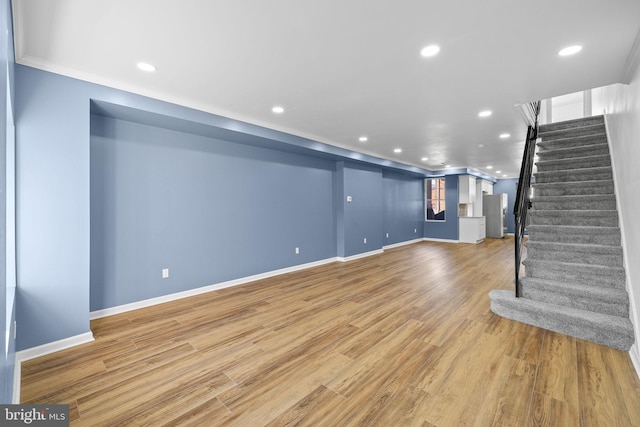 unfurnished living room with wood-type flooring and ornamental molding