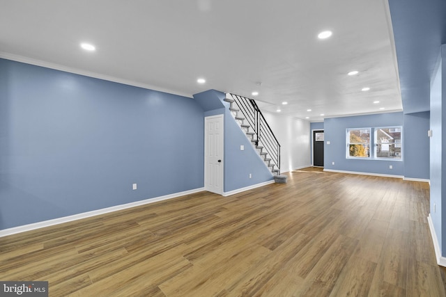 unfurnished living room featuring hardwood / wood-style flooring and ornamental molding