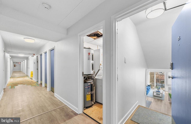 corridor featuring electric water heater, light wood-type flooring, and water heater