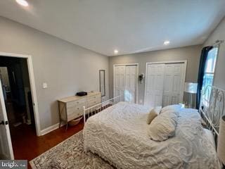 bedroom featuring dark hardwood / wood-style flooring and multiple closets