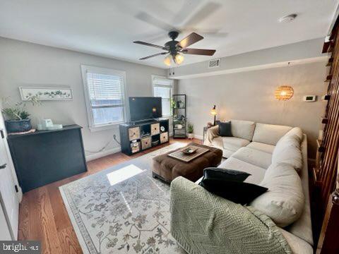 living room featuring hardwood / wood-style flooring and ceiling fan