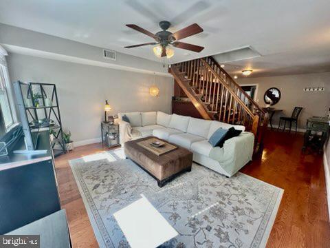 living room featuring ceiling fan and hardwood / wood-style floors