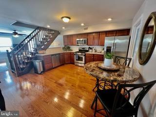 kitchen with appliances with stainless steel finishes, light wood-type flooring, and ceiling fan