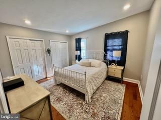 bedroom featuring dark hardwood / wood-style flooring and two closets