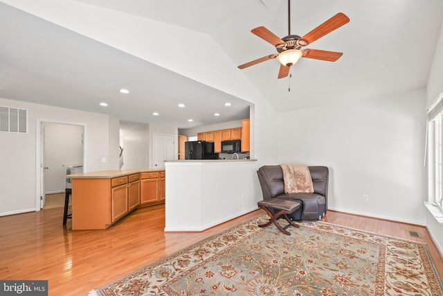 living room with lofted ceiling, ceiling fan, and light wood-type flooring