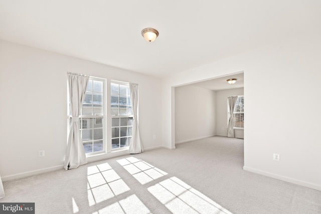 unfurnished room featuring light carpet