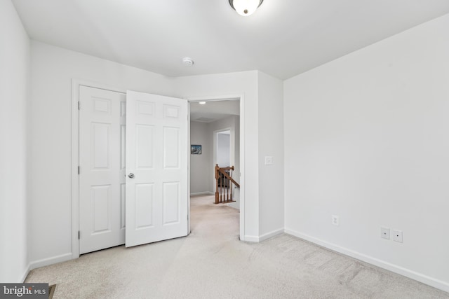 unfurnished bedroom featuring a closet and light carpet