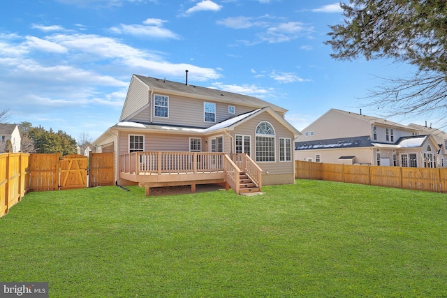 rear view of house featuring a yard and a deck