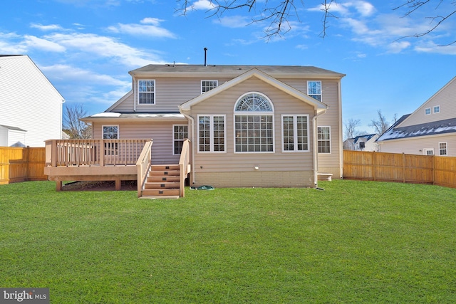 rear view of property with a yard and a deck