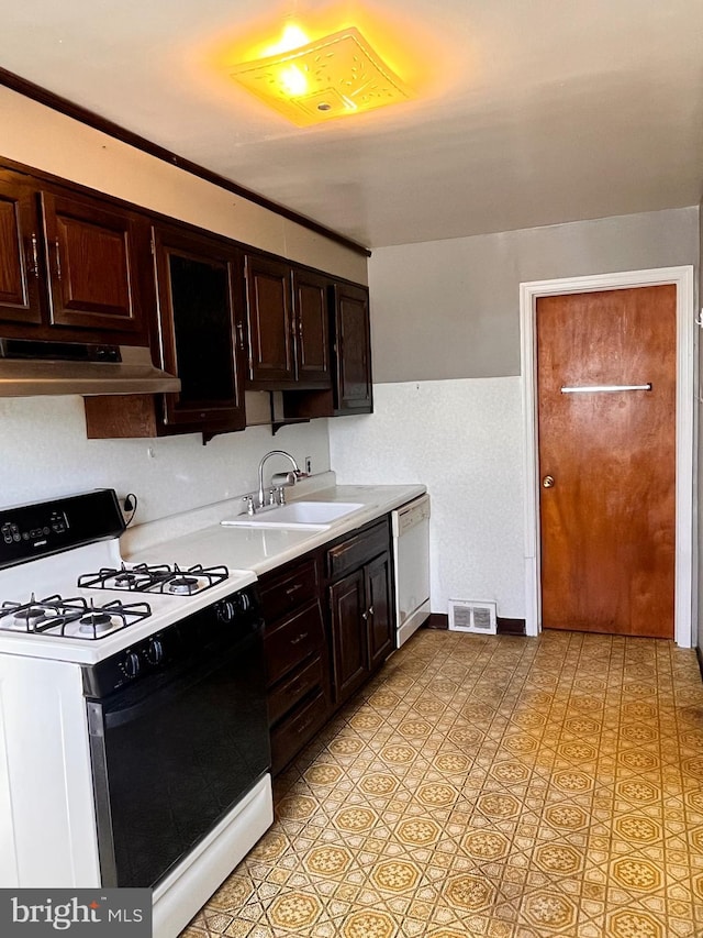 kitchen with sink, dark brown cabinets, range with gas stovetop, and white dishwasher