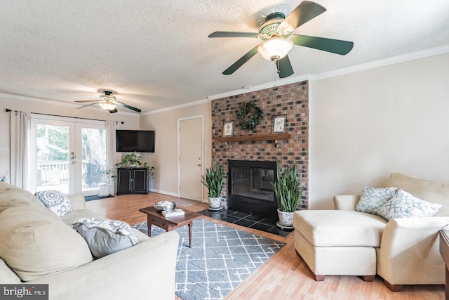 living room with french doors, a textured ceiling, ornamental molding, and hardwood / wood-style flooring