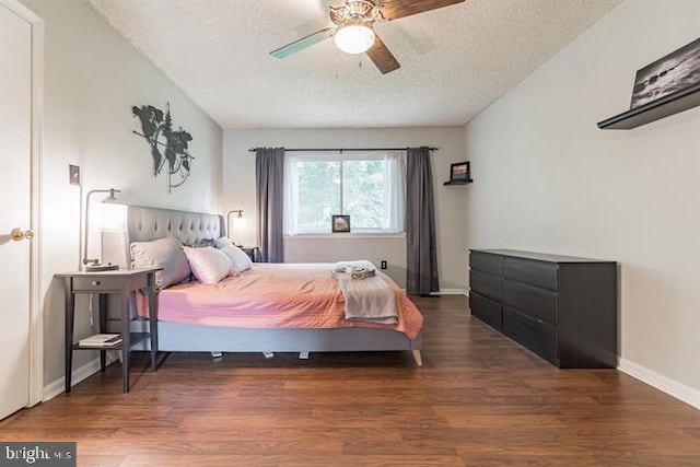 bedroom with dark wood-type flooring, a textured ceiling, and ceiling fan